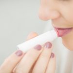 woman using lip balm