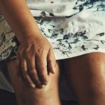 woman holding her knee