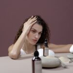 Γυναίκα που κάνει μασάζ στο τριχωτό της κεφαλής για scalp care και υγεία μαλλιών.