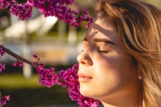 Γυναίκα που εφαρμόζει τεχνικές neuro-skincare για χαλάρωση και υγεία προσώπου.